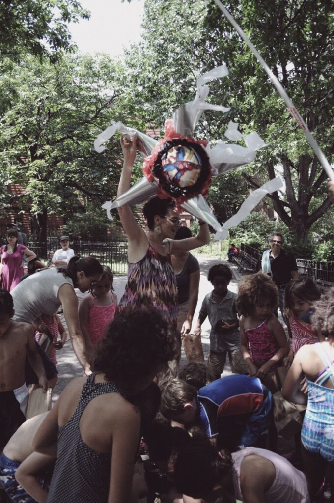Coco Fusco holding the piñata
