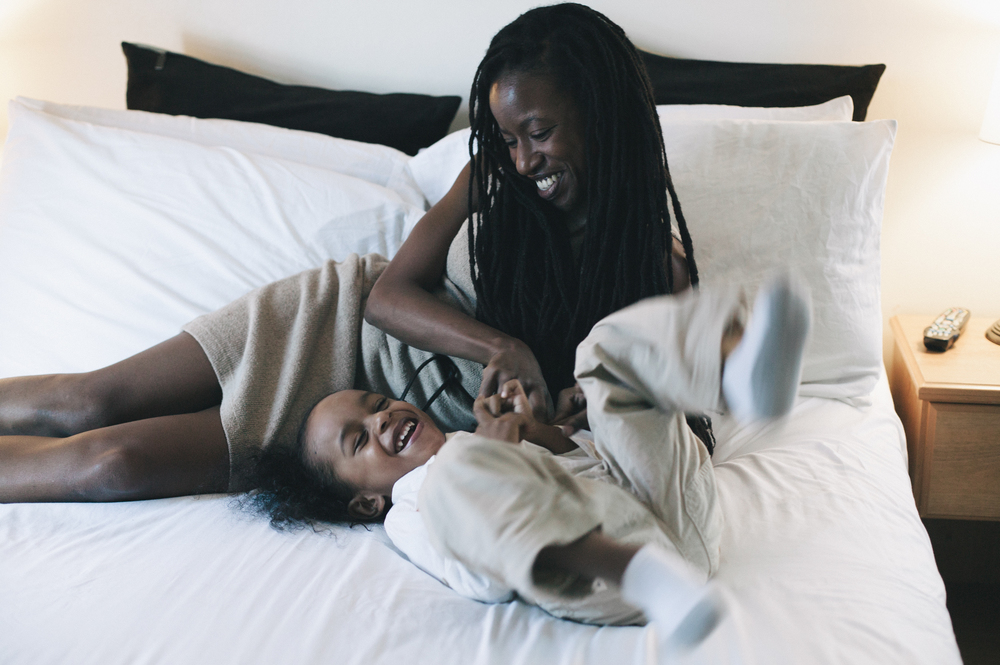 Makeda Thomas and her child playing on the bed