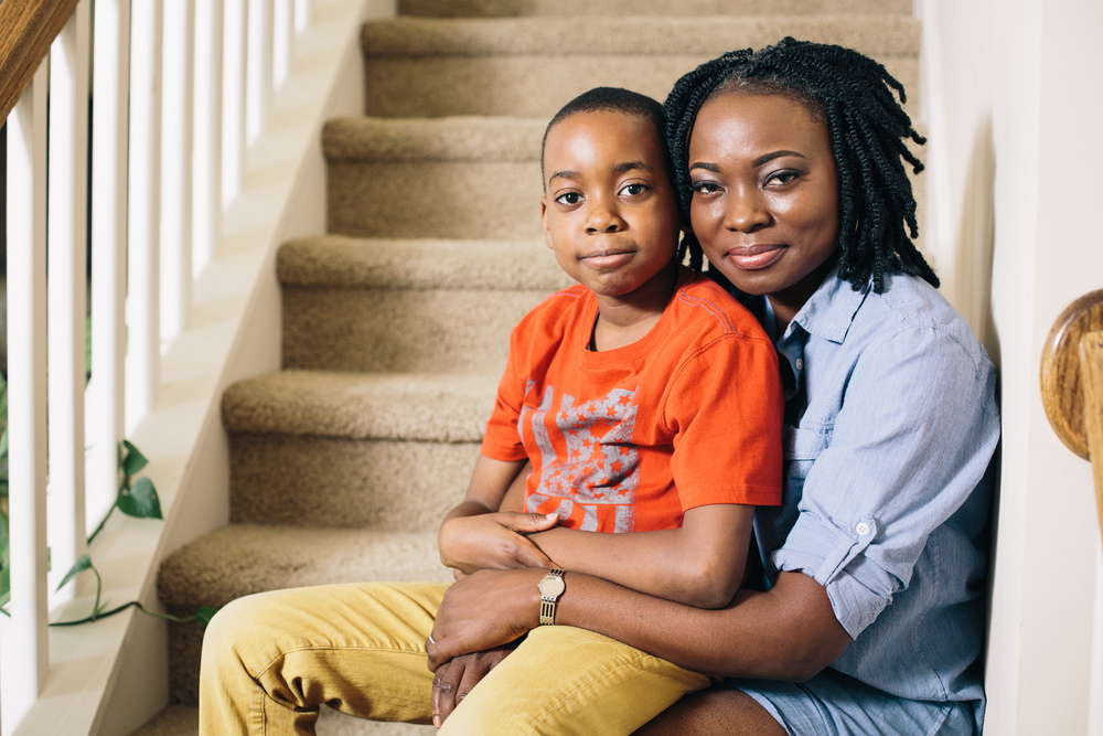 Agatha Achindu with her son, sitting on the stairs