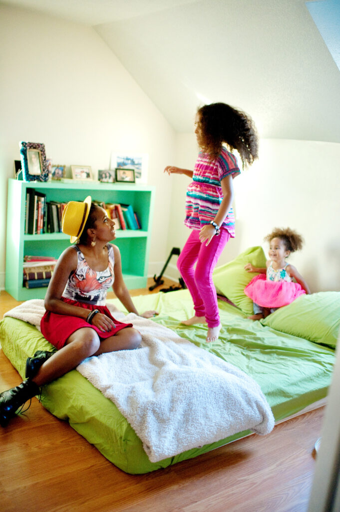 Sarah White playing with her children on the bed