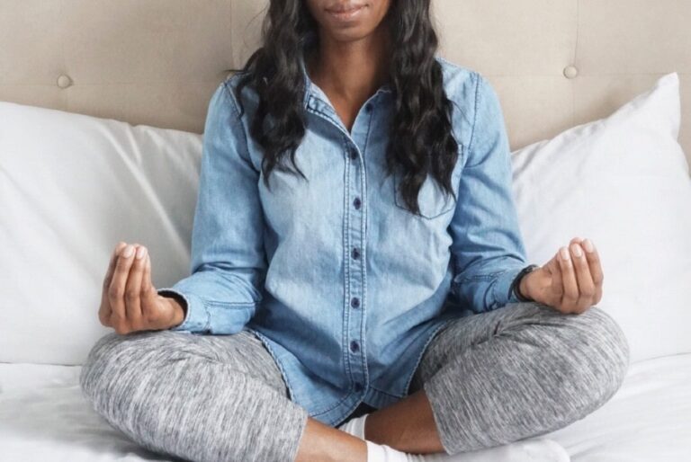 Black woman meditating in bed